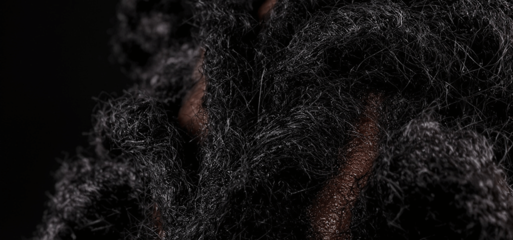 Close-up of a coil of Afro-textured hair showing the natural twists along the strand.